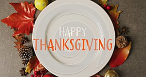 Animation of happy thanksgiving text over plate and leaves on grey background