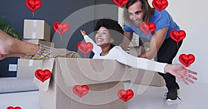 Animation of heart icons over happy diverse couple moving home