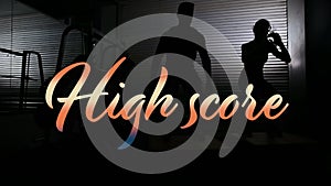 Animation of high score text in gradient orange over man and woman jumping in gym