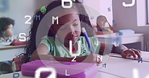 Animation of letters and numbers over biracial schoolgirl concentrating writing at desk in class