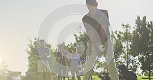 Animation of light trails over senior caucasian couple playing golf on golf course