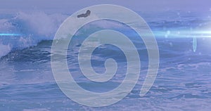 Animation of lights over caucasian male surfboarding on waves