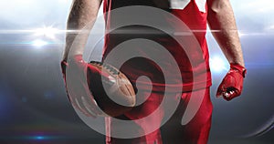 Animation of lights over midsection of american football player holding ball at floodlit stadium