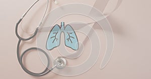 Animation of lungs over stethoscope and ribbon on pink background