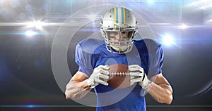 Animation male american football player holding ball at floodlit stadium