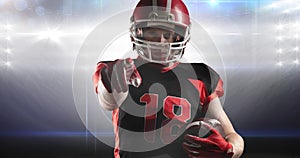 Animation of male american football player holding ball pointing, at floodlit stadium