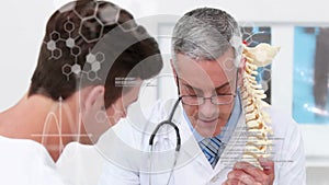 Animation of medical data processing over caucasian male doctor and patient discussing spine