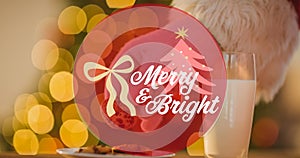 Animation of mery and bright christmas text over candies on wooden background