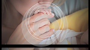 Animation of moving screens and geometrical shapes over caucasian mother kissing hand of her baby