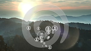 Animation of multiplying people icons moving over idyllic misty mountain landscape at sunset