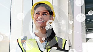 Animation of network of communication icons over happy biracial female architect in hard hat