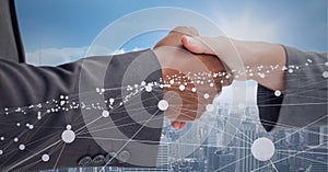 Animation of network of connections and cityscape over businessman and businesswoman shaking hands