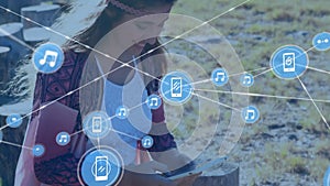 Animation of network of connections with devices icons over caucasian woman with tablet