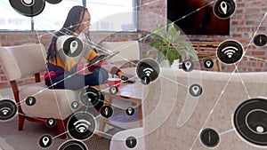 Animation of network of connections with wifi icons over african american woman using tablet