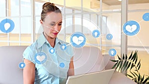 Animation of network of health and idea icons over happy caucasian casual businesswoman using laptop