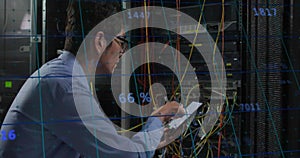 Animation of numbers over asian man working in server room