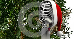 Animation of santa hat on vintage microphone over fir tree on white background