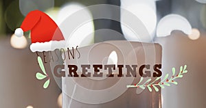 Animation of seasons greetings text over lit candles background