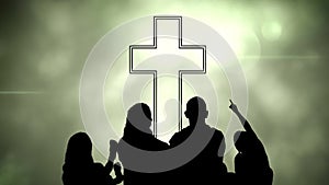 Animation of silhouette of Christian cross and a family over glowing green clouds