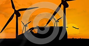 Animation of silhouetted delivery van moving over wind turbines and plane taking off on orange