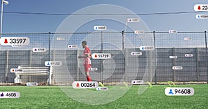 Animation of social media icons over african american male soccer player training on sports field