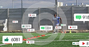 Animation of social media icons over african american male soccer player training on sports field