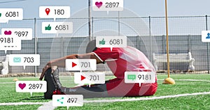 Animation of social media icons over biracial male soccer player with prosthetic leg stretching