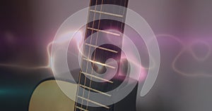 Animation of white, blue and pink light trails over acoustic guitar on smokey background