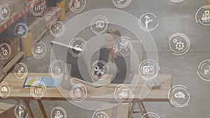 Animation of a woman working in a warehouse and using a computer with round icons