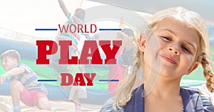 Animation of world play day over happy caucasian girl smiling at camera