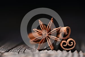 Anise star and cinnamon sticks on wooden board