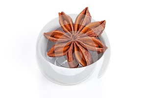 Anise star in a white bowl on white background