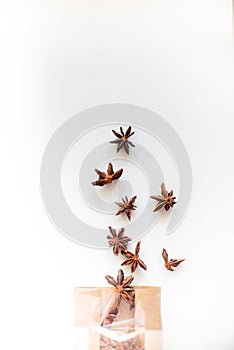 Anise tree seeds on white background and brown paper pocket.