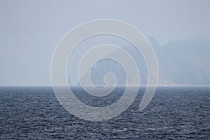 Aniva Cape of Sakhalin Island in dense fog. Lighthouse on separated rock. Sakhalin Island, La Perouse Strait, The Sea of Okhotsk,