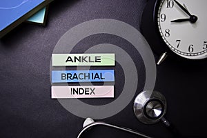 Ankle Brachial Index text on Sticky Notes. Top view isolated on black background. Healthcare/Medical concept photo