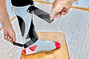 Ankle foot orthosis brace is fixed on leg with velcro straps.