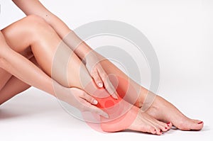 Ankle pain. Female legs. Woman massaging her ankle