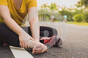 Ankle sprained. Young woman suffering from an ankle injury while jogging and running at the park. Healthcare and sport concept