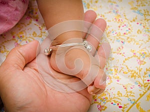 Anklet of newborns in mom's hand photo