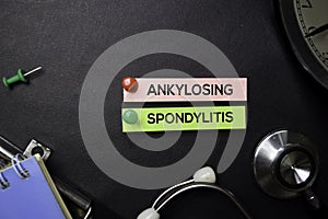 Ankylosing Spondylitis text on Sticky Notes. Top view isolated on black background. Healthcare/Medical concept