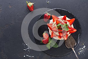 Anna Pavlova cake with strawberry on black background