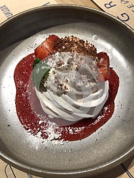 Anna Pavlova dessert with strawberry sauce and mint