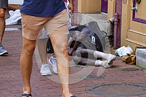 A homeless African American man sleeping on the street