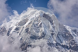 Annapurna South Summit surrounded by rising clouds in Himalayas