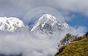 Annapurna South surrounded by clouds in the Himalayas