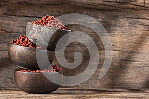 Annatto organic seeds in wooden bowls - Bixa Orellana
