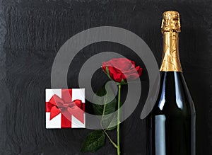 Anniversary background with champagne and gifts on natural slate stone