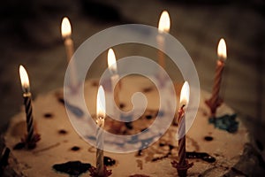 Anniversary cake with seven multi-colored candles lit