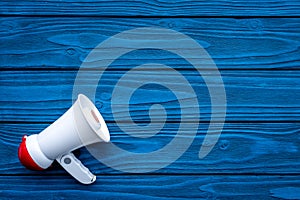 Announcement concept. Megaphone on blue wooden background top view copy space