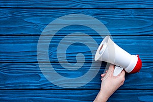 Announcement concept. Megaphone on blue wooden background top view copy space